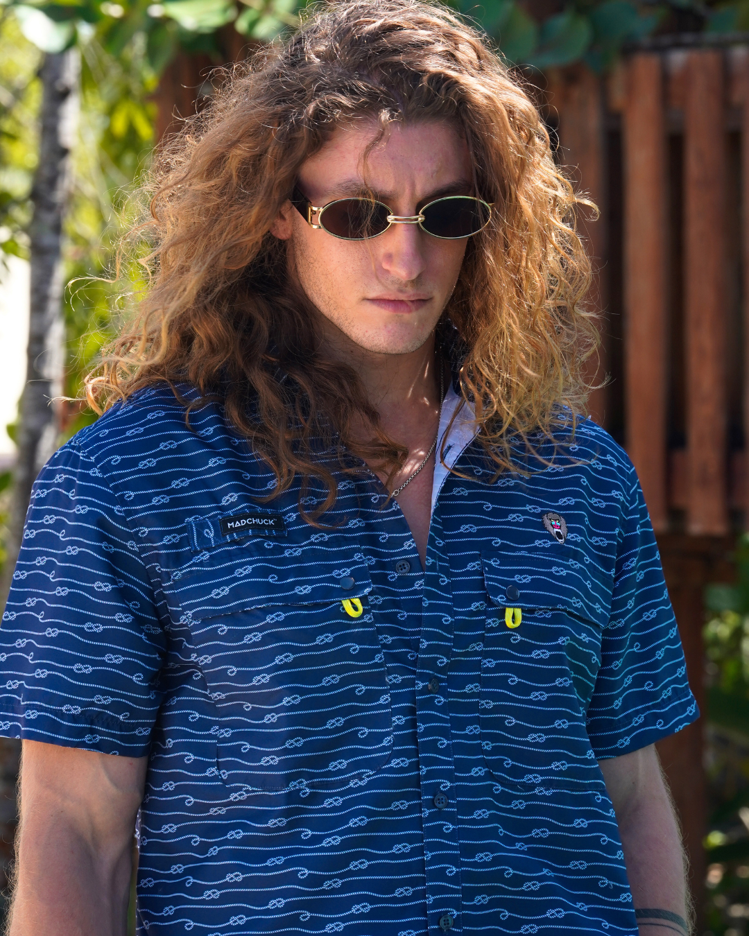 A male model wearing blue Mad Chuck polo.
