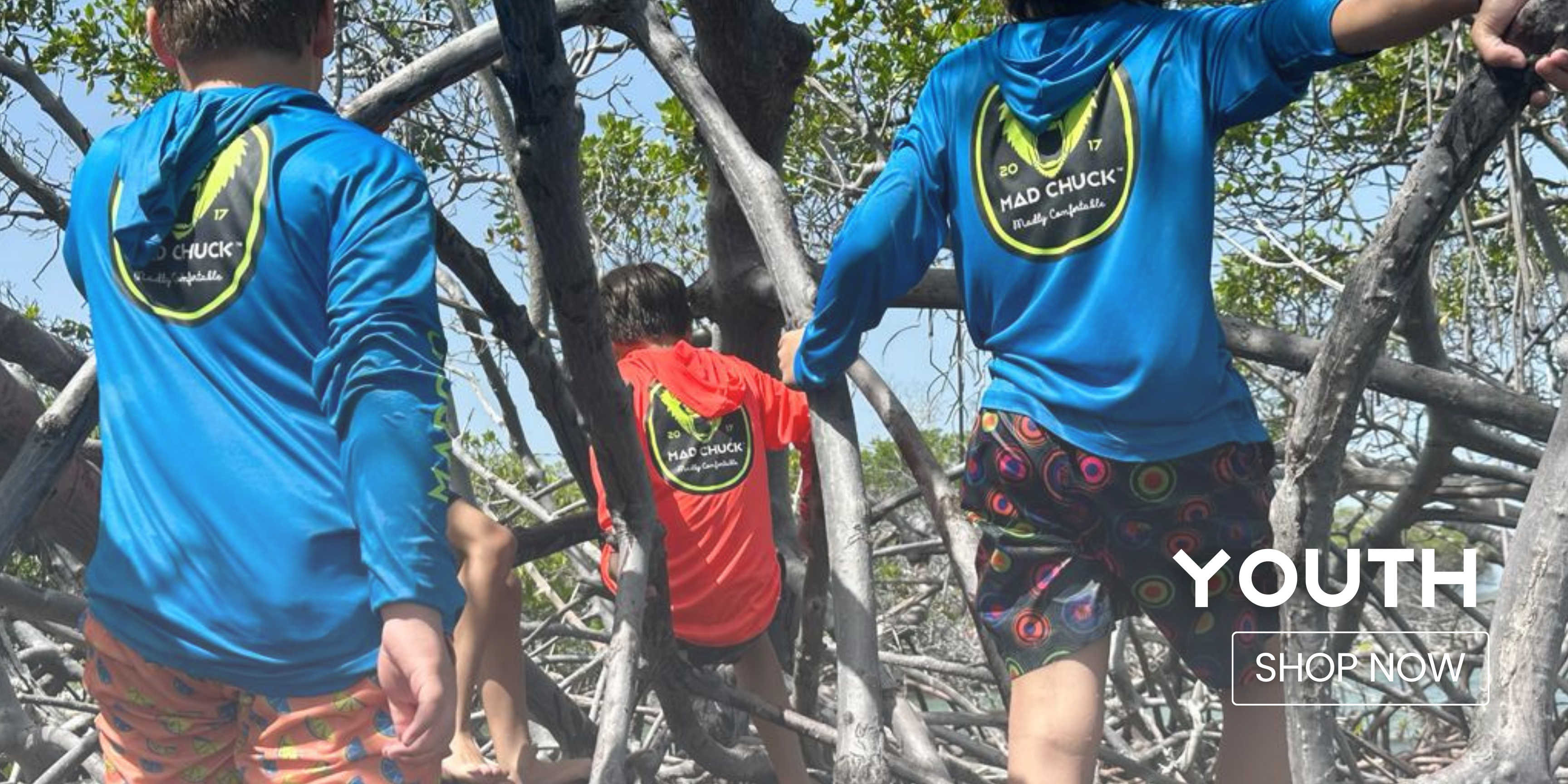 Youth Collection: Two youths wearing "Mad Chuck" Rashguards, climbing on tree branches. Click to browse Youth Collection